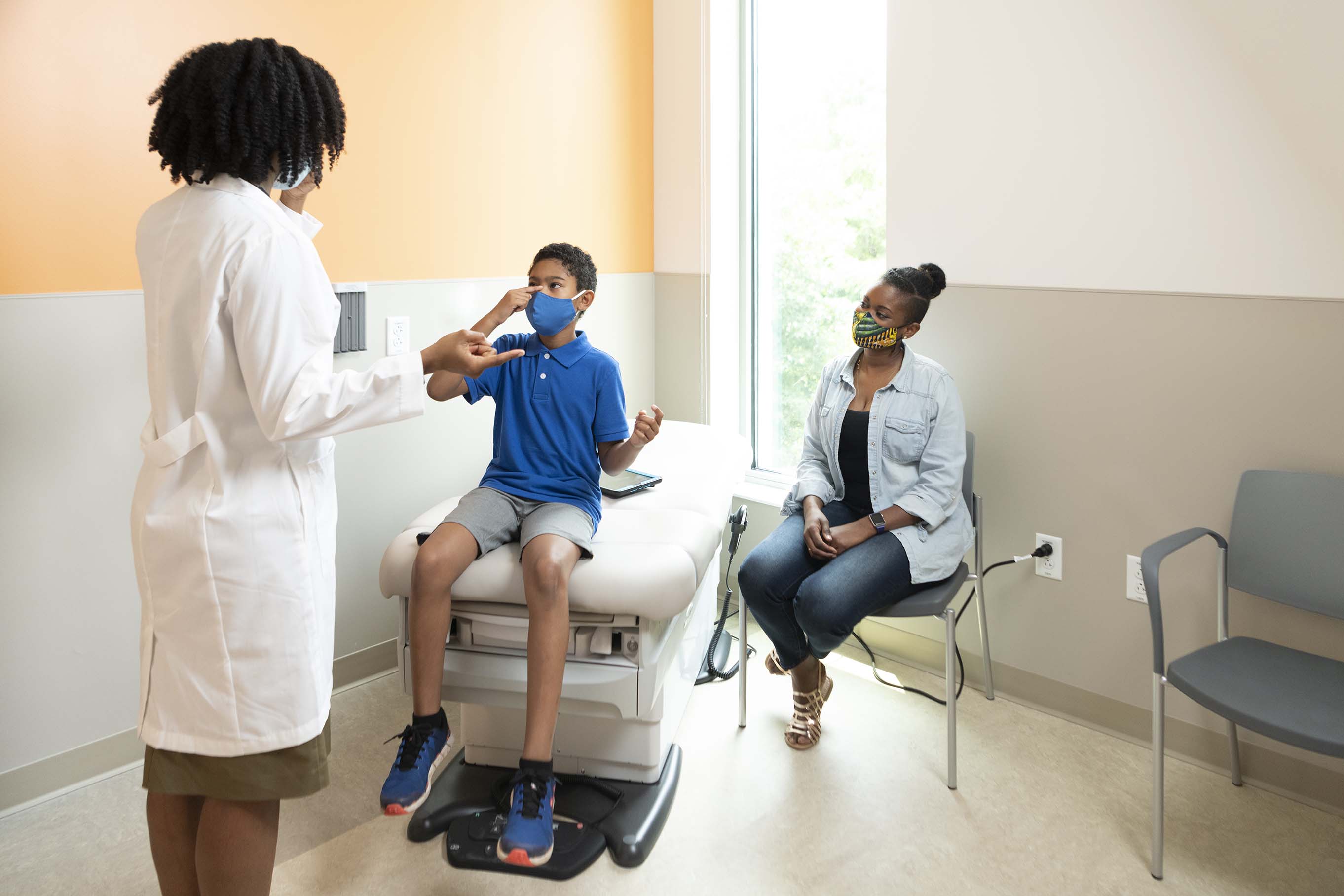 Young boy in pediatric exam room with pediatrician